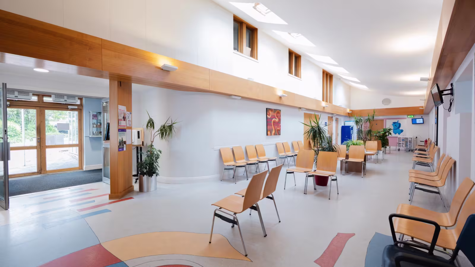 The main waiting area, with wooden chairs and a patterned floor